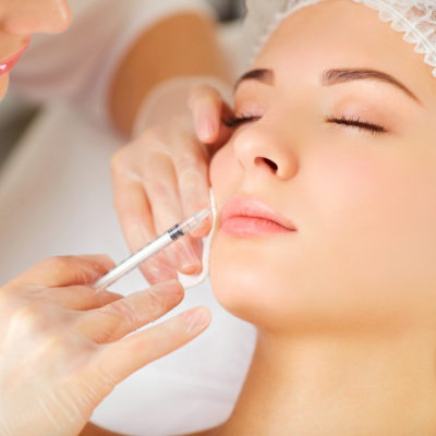 A woman receives an inejection on her face. A woman receives an inejection on her face in the clinic.